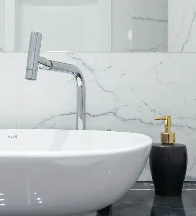 Mermer duvar önünde lavabo ve krom banyo bataryası